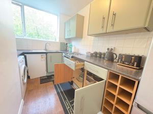 South NorwoodにあるCosy 2 bed flat Near East Croydonの白いキャビネットとカウンタートップを備えたキッチン +21枚の写真