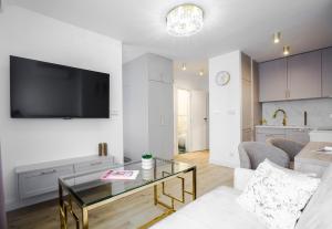 a living room with a tv on a wall at Apartament Glamour in Łańcut
