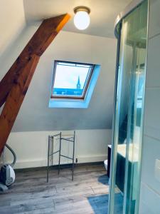 Una habitación abuhardillada con una ventana y una puerta de cristal. en Gravelines Beach Apartment, en Gravelines
