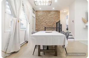 a dining room with a white table and chairs at Top Rated Vacation place Montreal in Laval
