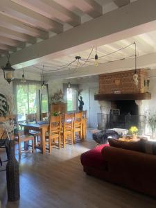 a living room with a table and chairs and a fireplace at la p’tite chaumière in Forges-les-Eaux