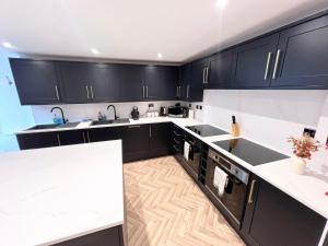 a kitchen with black cabinets and white counter tops at Eleven on Dragon - Boutique Hotel Rooms & Studio Apartment in Harrogate