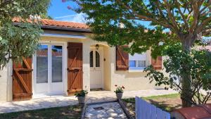 a house with a white door and a tree at Maison familiale à Fouras-Plage & centre à pied in Fouras
