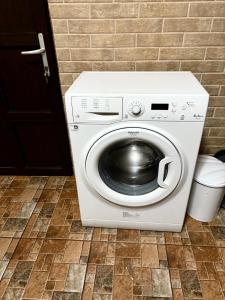 a white washing machine sitting on a tile floor at Apartament Leonardo in Roman