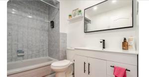 a bathroom with a toilet and a sink and a tub at Top Rated Vacation place Montreal in Laval