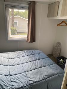 a bed in a room with a window at Résidence des dunes de Contis in Saint-Julien-en-Born