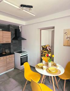 a kitchen with a table and yellow chairs in a room at Apartament słoneczny in Rydułtowy +7 photos
