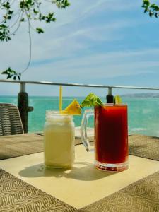 two drinks on a table with the ocean in the background at Los Picos Hotel & Suites Bucerias in Bucerías
