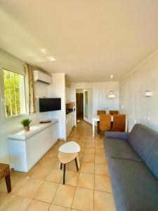 a living room with a blue couch and a kitchen at Restanques appartement vue mer in Grimaud +10 photos