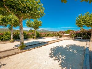 a park with trees and a bench and flowers at Appartement vue mer Domaine Les Restanques Grimaud in Grimaud +17 photos