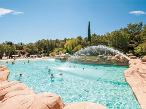 a group of people in a swimming pool with a fountain at Appartement vue mer Domaine Les Restanques Grimaud in Grimaud