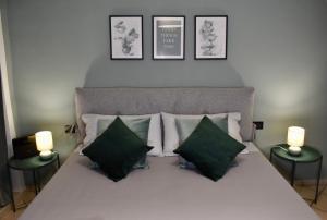 a bedroom with a bed with green and white pillows at La Ca Rosa in Cardano al Campo