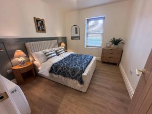 a bedroom with a large bed and a window at Dog Friendly 3 bedroom apartment in Leyburn