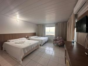 a hotel room with two beds and a television at Juscelino Pousada lazer in Tibau +53 photos