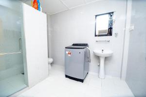 Un baño blanco con lavabo e inodoro. en Trinco Nathu Rest, en Trincomalee