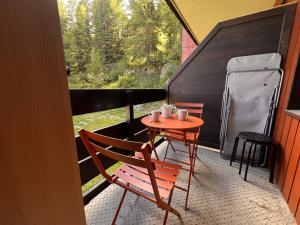 a small table and chairs on a screened in porch at Appartement lumineux avec balcon et parking in La Plagne Tarentaise