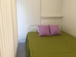 a bed with a purple pillow in a room at Karavanai "Aušroje" in Šventoji +54 photos