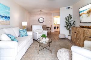 a living room with a white couch and a table at The all-new Summer House on Romar Beach-gulf front in Orange Beach