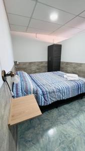 a bedroom with a bed with a blue comforter at Departamento Cerro Catedral in Neuquén