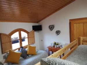 a bedroom with two beds and a wooden ceiling at Ca l'Andròmines in Pinell de Bray
