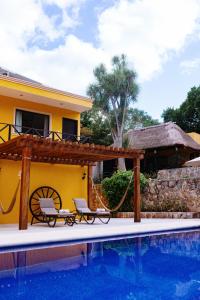 a villa with a swimming pool and a house at Hotel Rinconada del Convento in Izamal