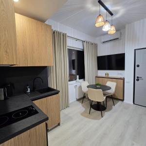 Una cocina y un comedor con una mesa y un televisor. en Studio Tabacariei 5B, en Tăbăcărie