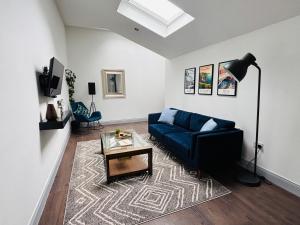a living room with a blue couch and a table at Twenty 7 - Modern & Spacious Townhouse in Killaloe