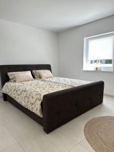a large bed in a white room with a window at Domi Apartment in Gerolstein
