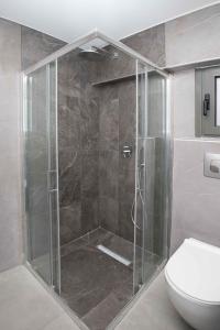 a shower with a glass door next to a toilet at Ilissos Harmony Apartment in Piraeus +55 photos