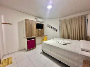 ein Schlafzimmer mit einem Bett und einem Fernseher in der Unterkunft Juscelino Pousada lazer in Tibau
