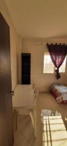 Cette chambre comprend une table, un lit et une fenêtre. dans l'établissement APPT A Louer MARTIL, à Martil