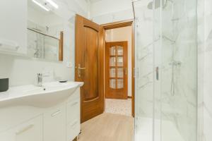 Un baño blanco con lavabo y ducha. en Patty Flat - 15 min from Venice & Free Parking, en Venecia 40 fotos más