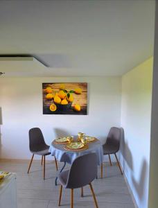 a dining room with a table with chairs and a painting at Rosa in Rydułtowy