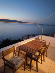 a wooden table and chairs on a balcony overlooking the water at "Villa Kanella"Sea View Hydra Kamini malouholidays in Hydra