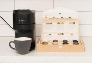 una caja de donas junto a una taza de café en Beautiful townhouse in Cardiff Bay, en Cardiff