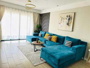 a living room with a blue couch and a table at Homely Haven Two Bedroom Near JKIA in Nairobi