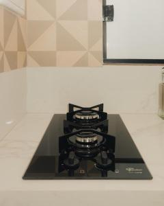 a stove top oven sitting on a kitchen counter at Loft Aconchegante & bem localizado 04 in Feira de Santana