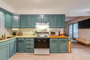 eine Küche mit grünen Schränken und einer Mikrowelle in der Unterkunft Warm and Cozy 3BR-8 Mi to Ocean City! in Ocean Pines