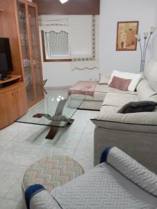 a living room with several couches and a tv at Piso Sol y Mar vacacional in Moaña