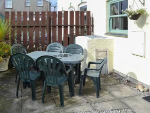ein Tisch und Stühle auf einer Terrasse in der Unterkunft Willow Cottage in Newlyn East + 7 Fotos