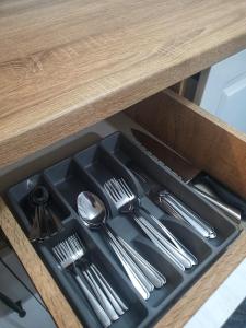 a tray with silver utensils in a drawer at Yan's House apartament 2 camere decomandat in Drobeta-Turnu Severin +20 photos