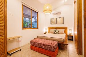 a bedroom with a bed and a table and a window at Namaitami in Talamanca