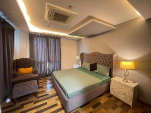 拉合尔Modern Luxury 1 BHK Apartment At Goldcrest Mall DHA Phase 4 Lahore的卧室里有一张床和一把椅子