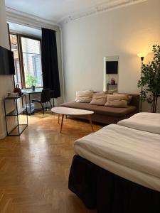 ヨーテボリにあるHotel Lemonadeのベッド2台とソファのあるリビングルーム +57枚の写真