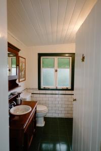 Un baño con inodoro, lavabo y ventana. en Lacey's Creek Homestead, en Ocean View 53 fotos más