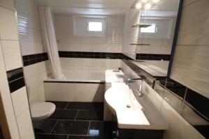 a bathroom with a sink and a toilet at Multiple rooms near the station Bolligen in Bolligen