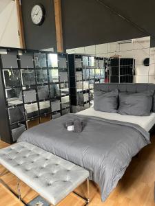 ein großes Bett in einem Zimmer mit einer Uhr an der Wand in der Unterkunft Big Loft in Empfingen