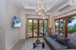 a living room with a couch and a table at BOHO Boutique Bungalows in Baan Tai
