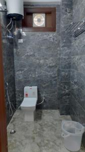 a bathroom with a toilet and a window at Dreamland Resort in Nainital +36 photos