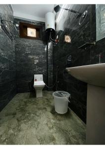 a bathroom with a white toilet and a sink at Dreamland Resort in Nainital